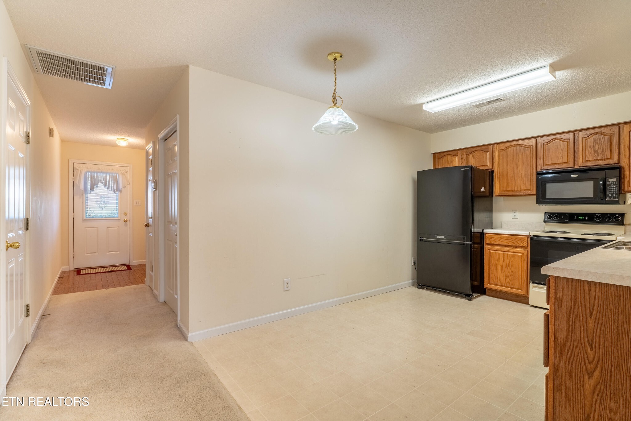 8024 Stablegate Way Powell, TN 37849 - Photo 8 of 35 a view of a kitchen with a refrigerator a microwave and a sink
