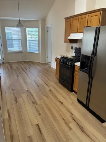 a kitchen with granite countertop wooden floors and stainless steel appliances