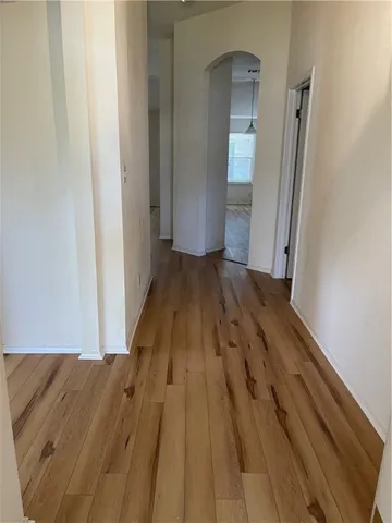 a view of a hallway with wooden floor and entryway