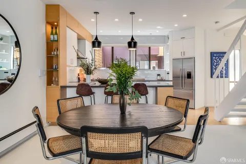 a kitchen with stainless steel appliances granite countertop a sink a microwave a refrigerator and white cabinets