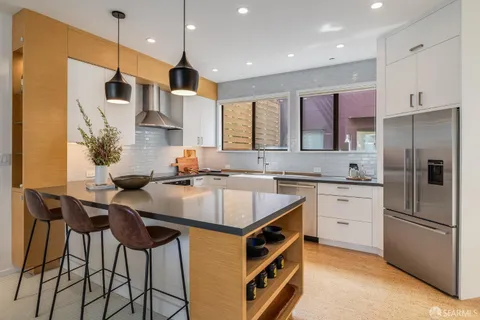 a kitchen with a sink a stove and white cabinets