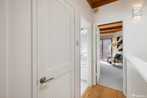 a view of staircase with wooden floor and lots of frames on wall