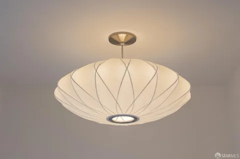 a view of a room with a hanging light and kitchen