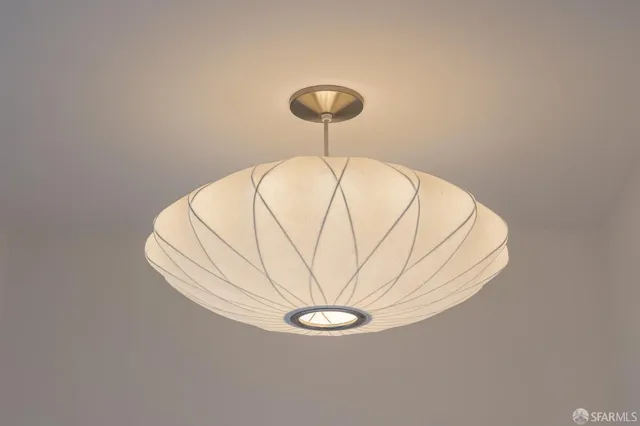 a view of a room with a hanging light and kitchen