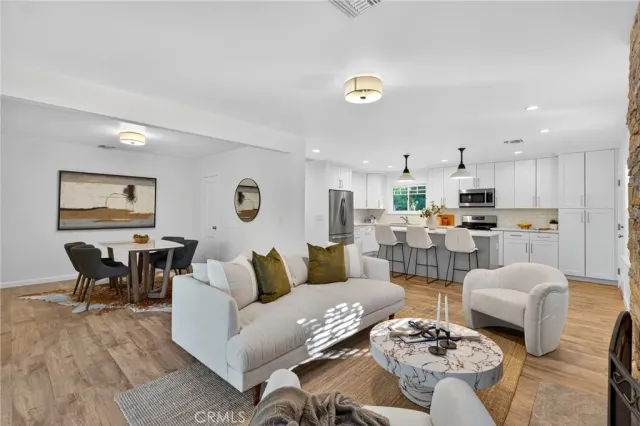 a living room with lots of furniture and kitchen view