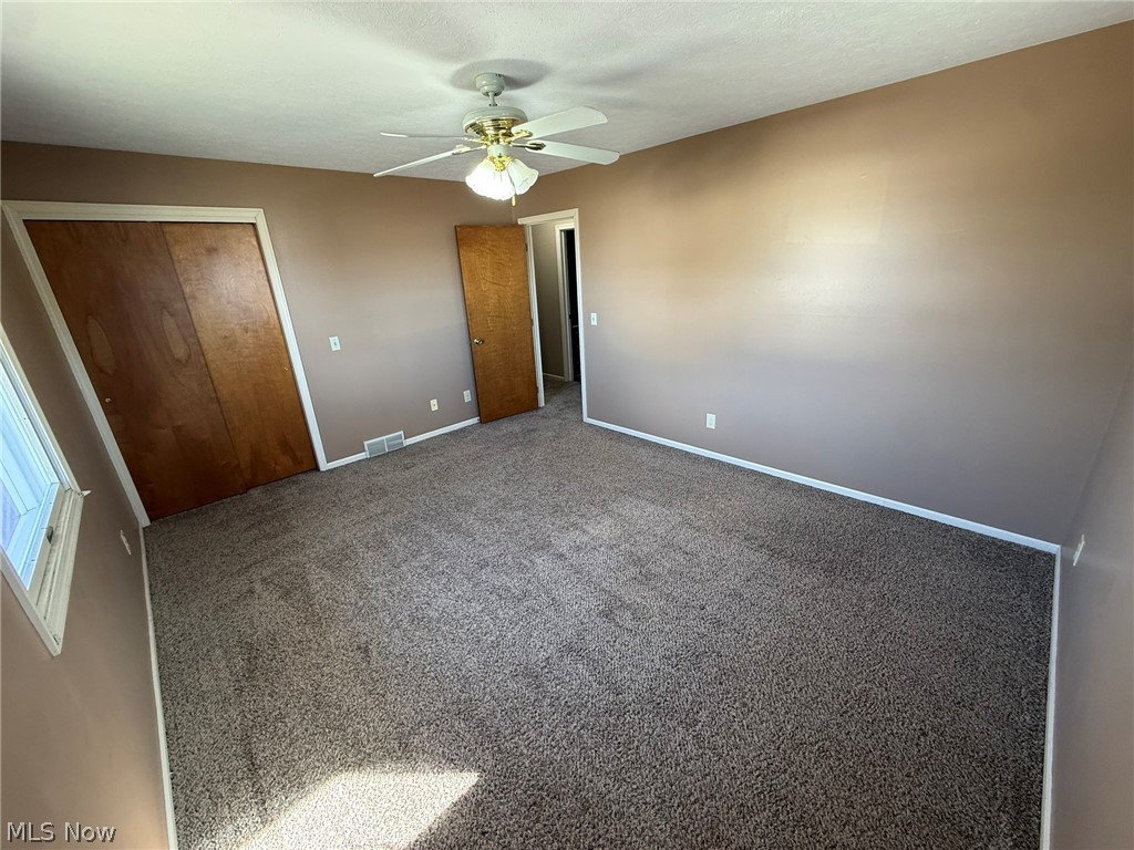 604 Harger Street Dover, OH 44622 - Photo 13 of 25 Unfurnished bedroom featuring carpet flooring, a closet, and a ceiling fan