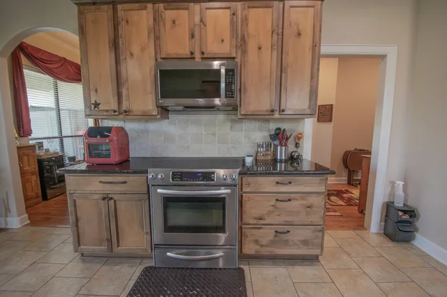 a kitchen with stainless steel appliances granite countertop a stove refrigerator and a sink