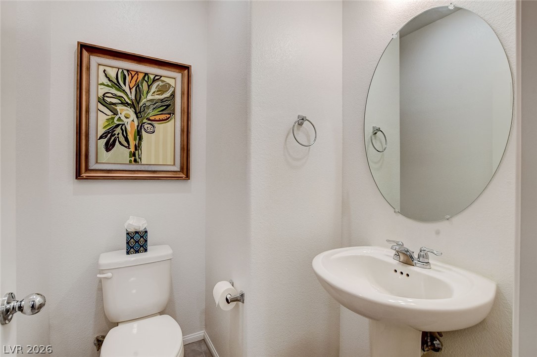 484 Filaree Place Henderson, NV 89015 - Photo 23 of 71 This bathroom features a contemporary pedestal sink and a sleek oval mirror.
