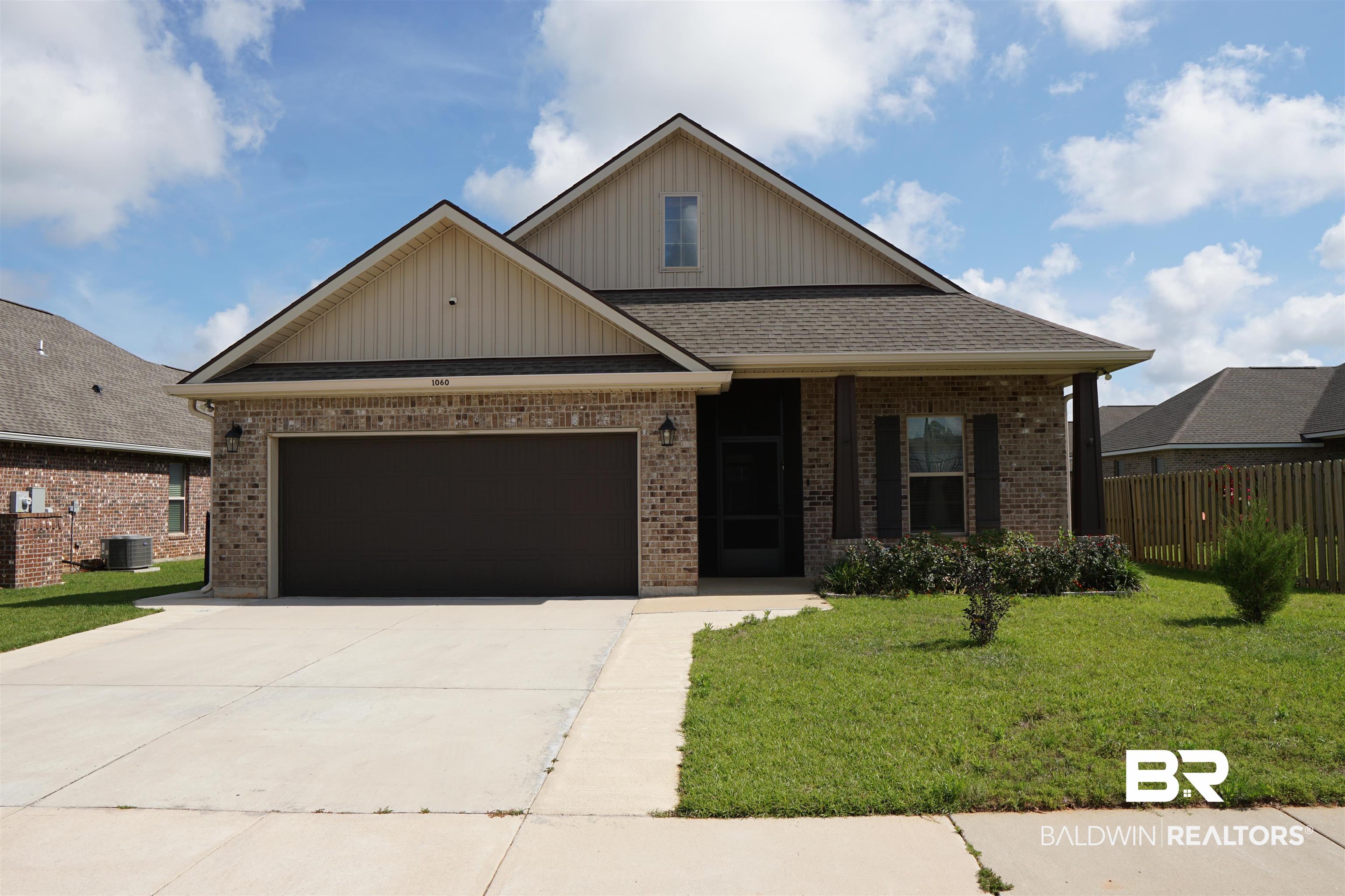 1060 Chloe Street Foley, AL 36535 - Photo 26 of 28 Brick exterior with gabled roofline, featuring a two-car garage, concrete driveway, and covered front entry