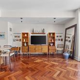 a living room with furniture a flat screen tv and kitchen view