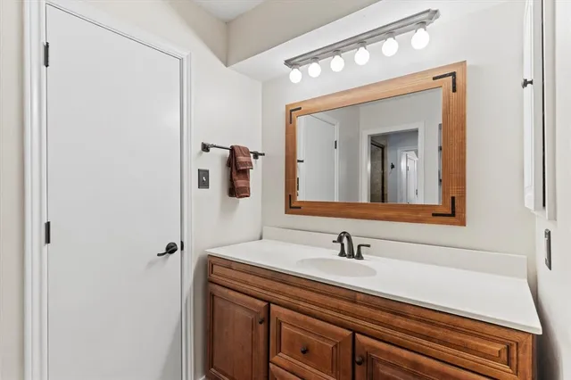 a bathroom with a sink a light fixture and a mirror