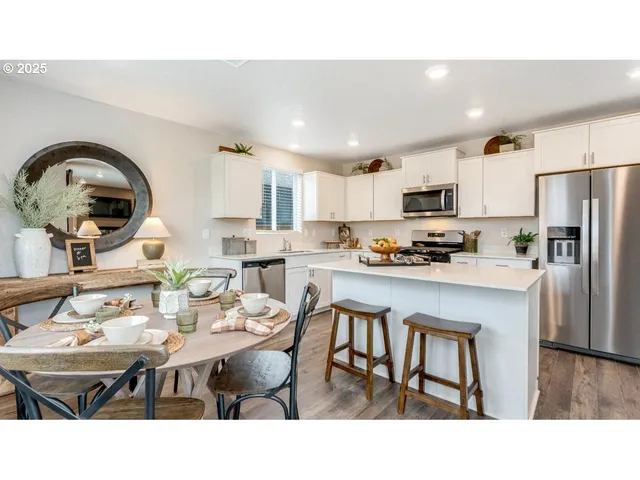 a kitchen with a table chairs a stove a microwave and dining room view