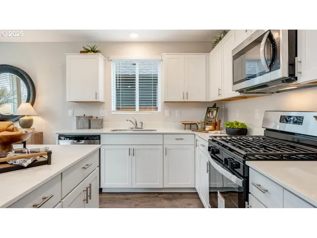 a kitchen with stainless steel appliances a stove a sink and cabinets