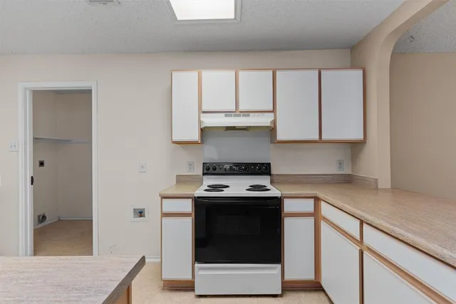 a kitchen with granite countertop white cabinets and white appliances