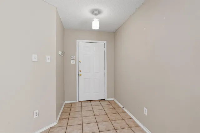 a view of an empty room and chandelier fan