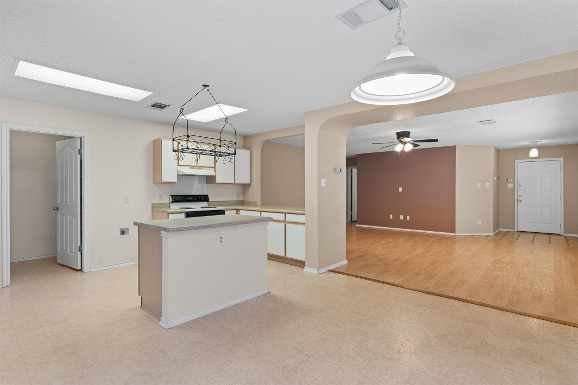 1353 Lakeside Loop Round Rock, TX 78665 - Photo 9 of 29 a kitchen with kitchen island granite countertop a stove a sink and a chandelier