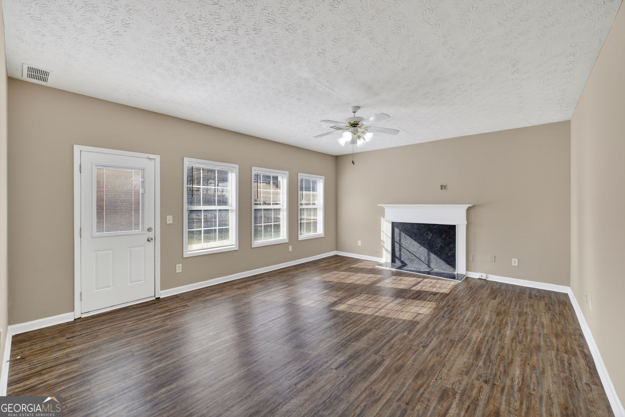 15 Parc Lane Covington, GA 30016 - Photo 13 of 30 a view of an empty room with wooden floor and a window