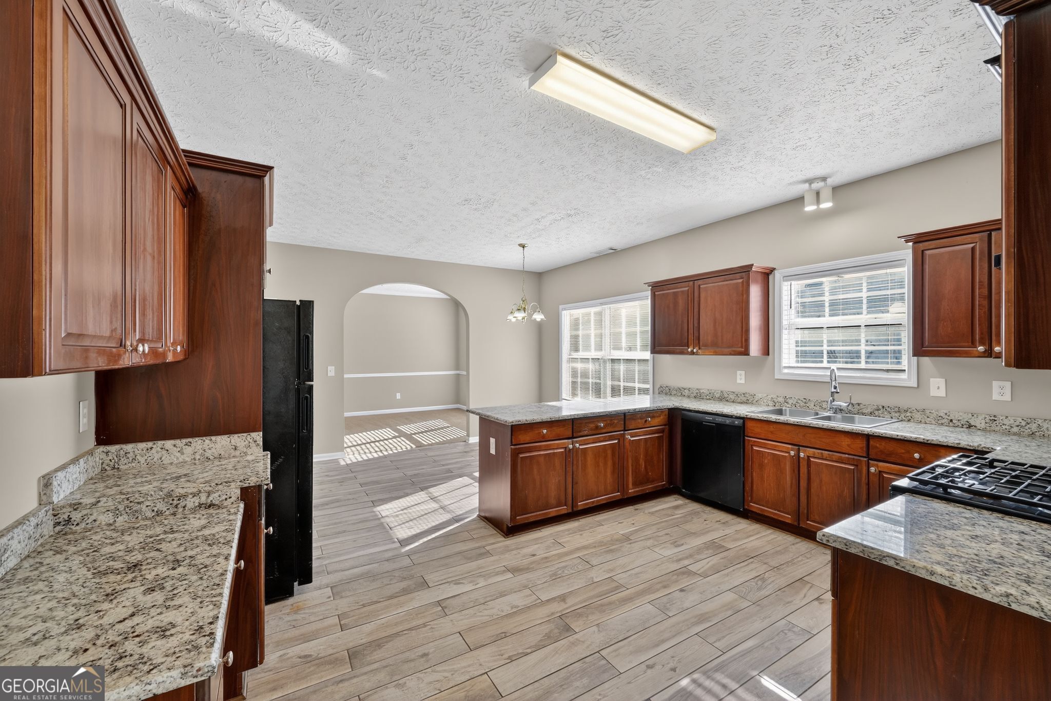 15 Parc Lane Covington, GA 30016 - Photo 16 of 30 a large kitchen with stainless steel appliances granite countertop a sink and wooden cabinets