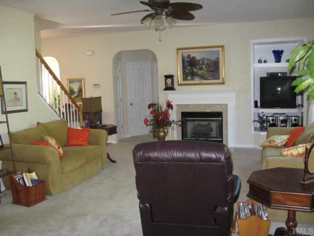 3521 Weir Way Raleigh, NC 27616 - Photo 2 of 12 a living room with furniture a fireplace and a flat screen tv