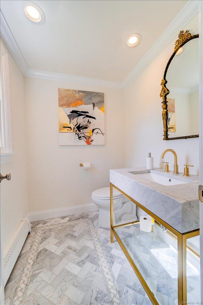 78 Schultz Hill Road Staatsburg, NY 12580 - Photo 24 of 50 Half bathroom with baseboard heating, toilet, crown molding, recessed lighting, and vanity