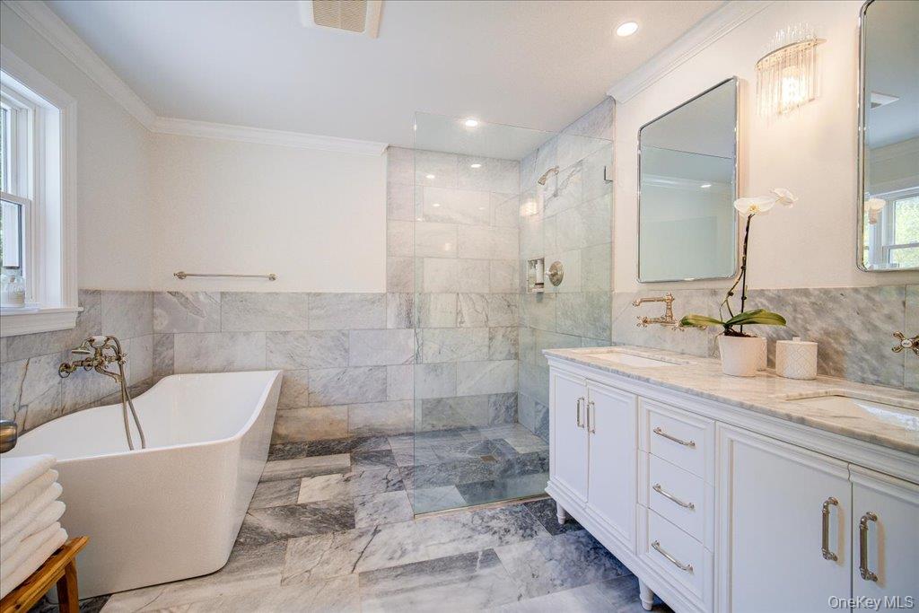 78 Schultz Hill Road Staatsburg, NY 12580 - Photo 28 of 50 Bathroom with crown molding, a soaking tub, a walk in shower, tile walls, and double vanity