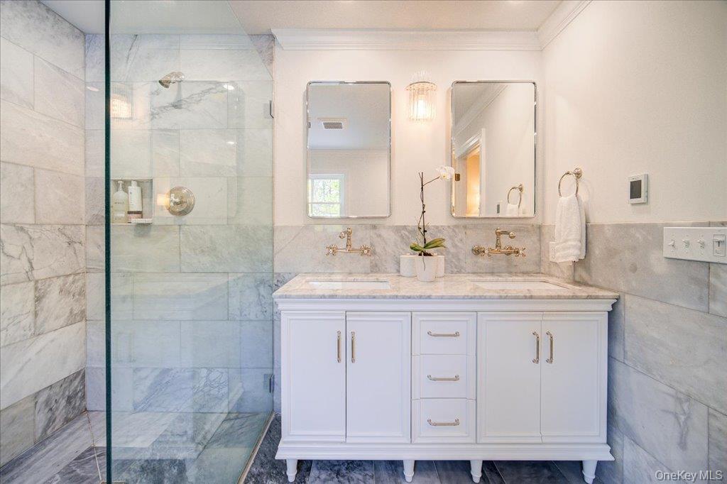 78 Schultz Hill Road Staatsburg, NY 12580 - Photo 30 of 50 Bathroom featuring tile walls, crown molding, a walk in shower, and double vanity