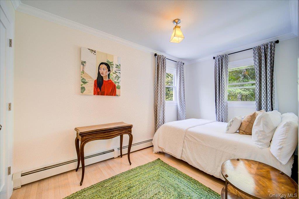 78 Schultz Hill Road Staatsburg, NY 12580 - Photo 39 of 50 Bedroom featuring baseboard heating, light wood-style flooring, and ornamental molding