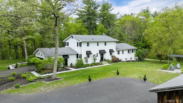 a view of a house with backyard and trees