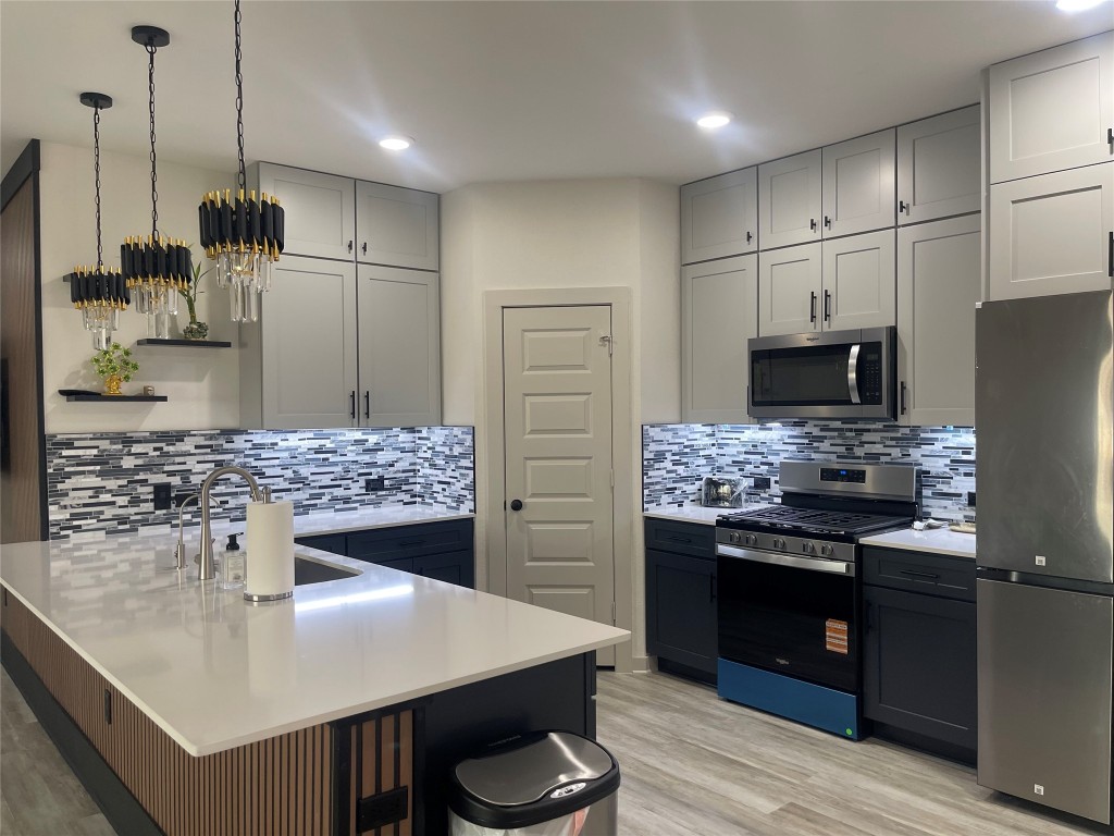 145 Merrick Road Georgetown, TX 78628 - Photo 15 of 33 a kitchen with a sink stainless steel appliances and white cabinets