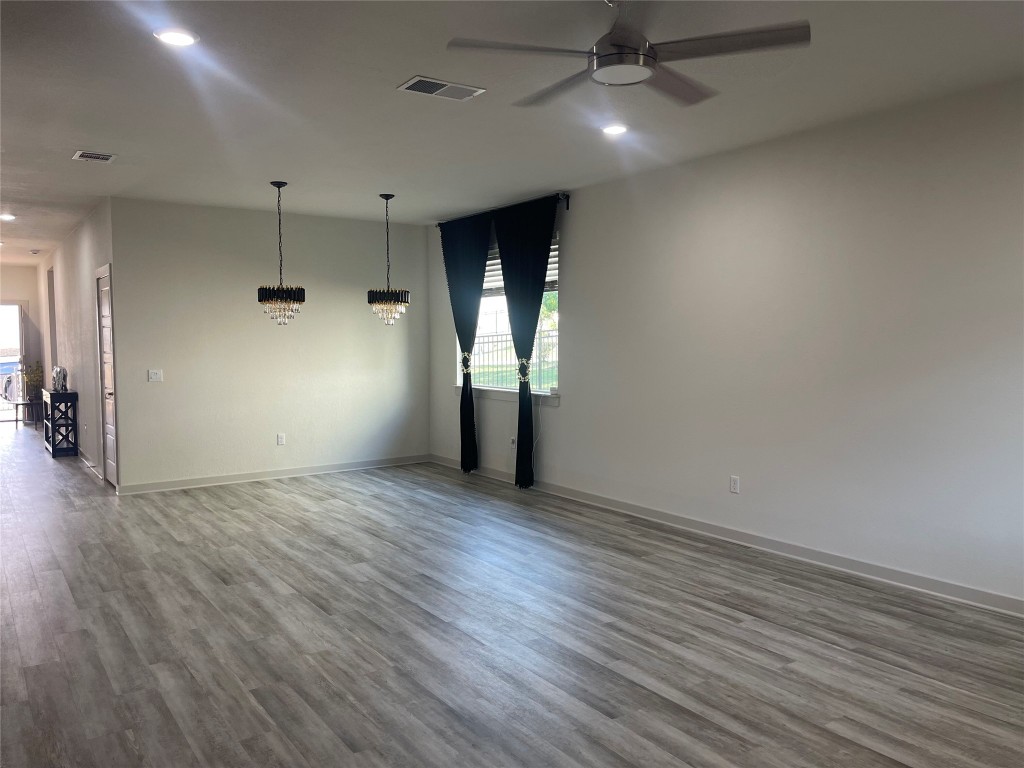 145 Merrick Road Georgetown, TX 78628 - Photo 16 of 33 an empty room with wooden floor and windows