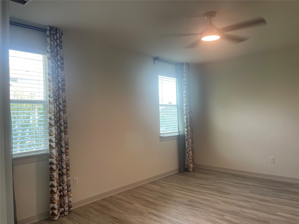 145 Merrick Road Georgetown, TX 78628 - Photo 22 of 33 an empty room with wooden floor and windows