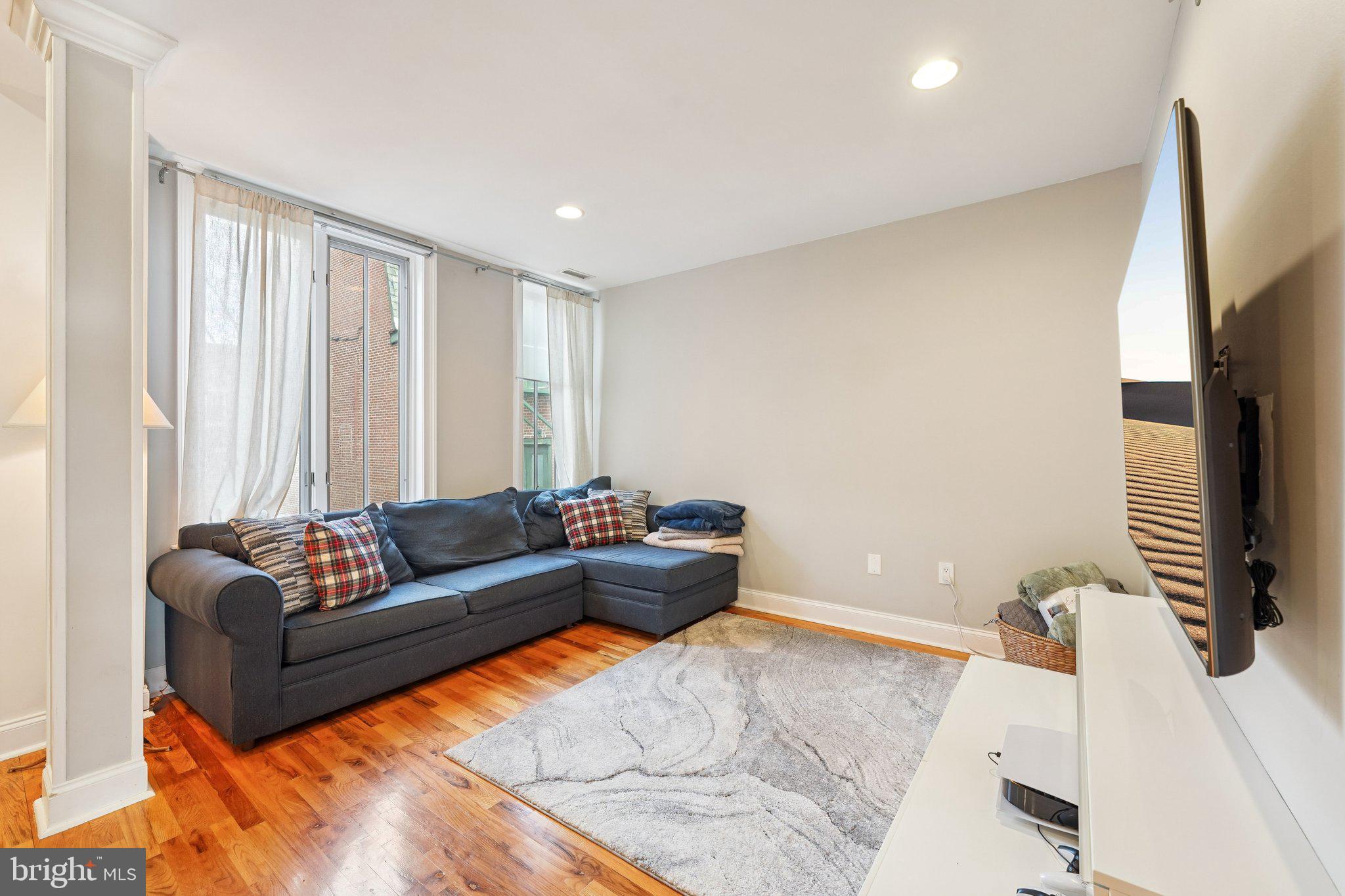 920 Clinton Street, Unit 3R Philadelphia, PA 19107 - Photo 11 of 24 a living room with furniture and a flat screen tv