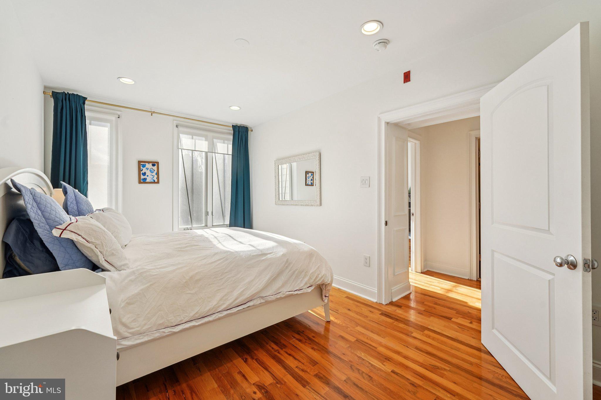 920 Clinton Street, Unit 3R Philadelphia, PA 19107 - Photo 16 of 24 a bedroom with a bed and wooden floor