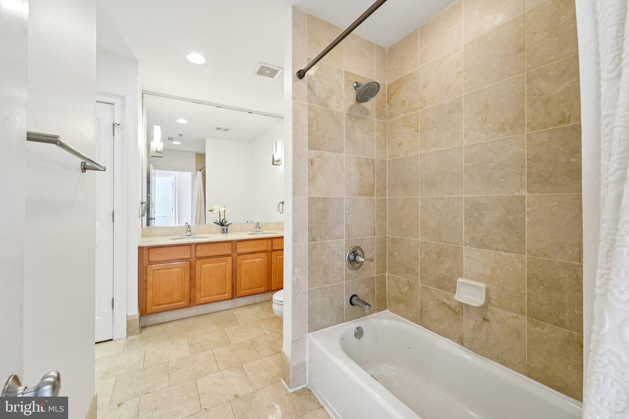 920 Clinton Street, Unit 3R Philadelphia, PA 19107 - Photo 18 of 24 a bathroom with a granite countertop sink a toilet tub and shower