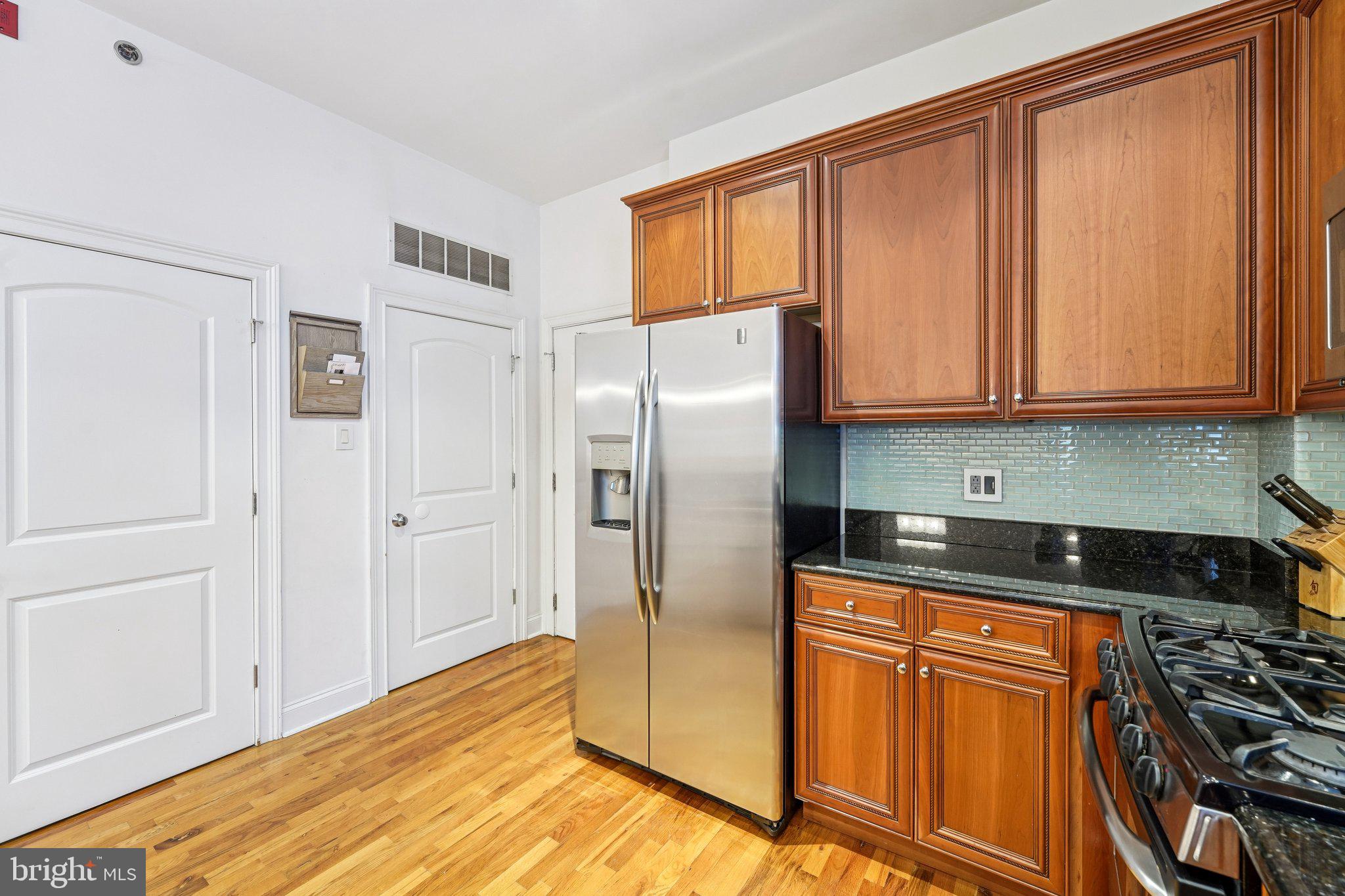 920 Clinton Street, Unit 3R Philadelphia, PA 19107 - Photo 6 of 24 a kitchen with stainless steel appliances granite countertop a refrigerator and a stove top oven