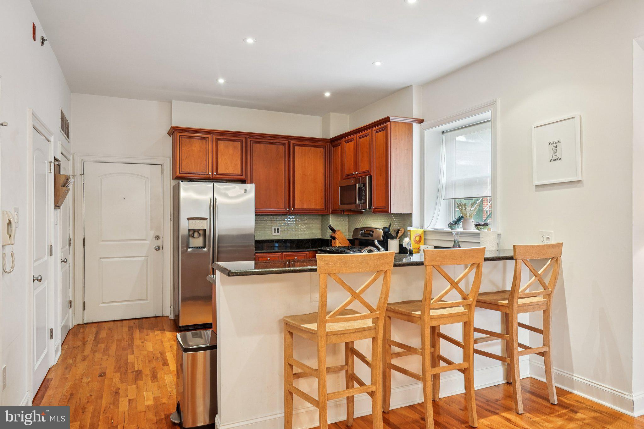 920 Clinton Street, Unit 3R Philadelphia, PA 19107 - Photo 7 of 24 a kitchen with stainless steel appliances granite countertop a refrigerator and a stove top oven