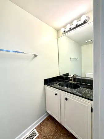 a bathroom with a granite countertop sink and a mirror
