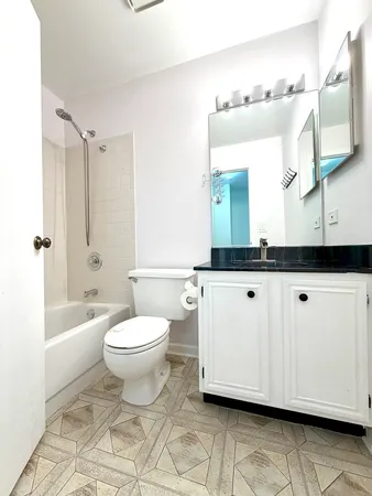 a bathroom with a granite countertop toilet sink and mirror