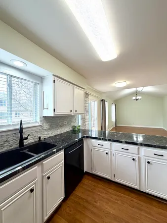 a kitchen with granite countertop a sink and cabinets