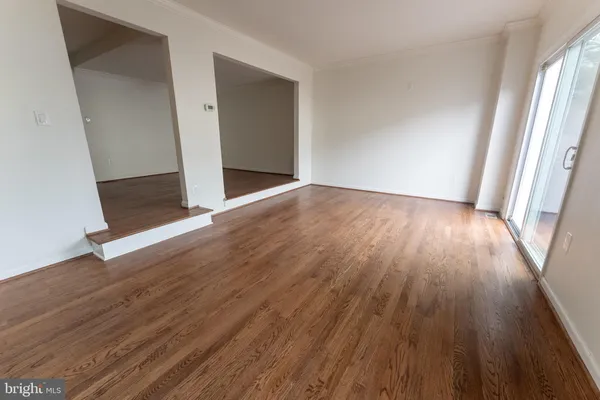 an empty room with wooden floor and entrance