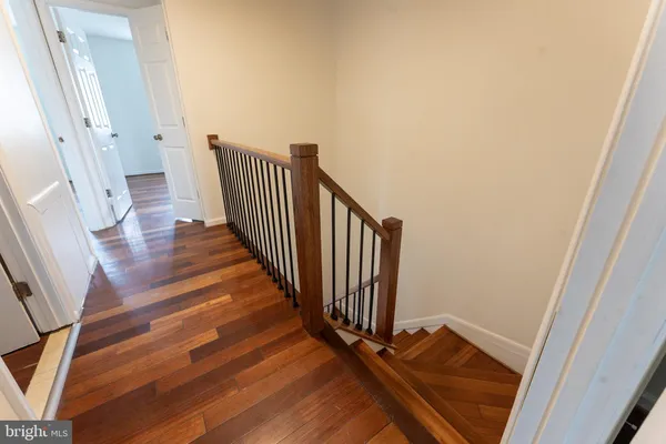 a view of a hallway with wooden floor and staircase
