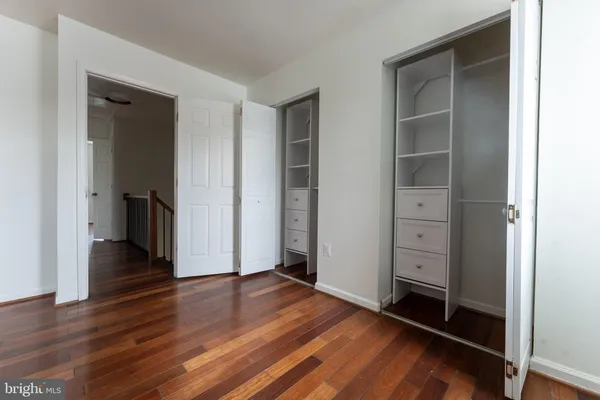 an empty room with wooden floor and closet