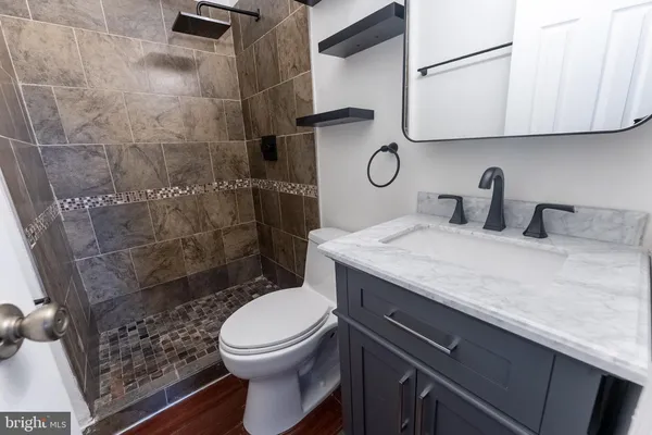 a bathroom with a granite countertop toilet sink and shower