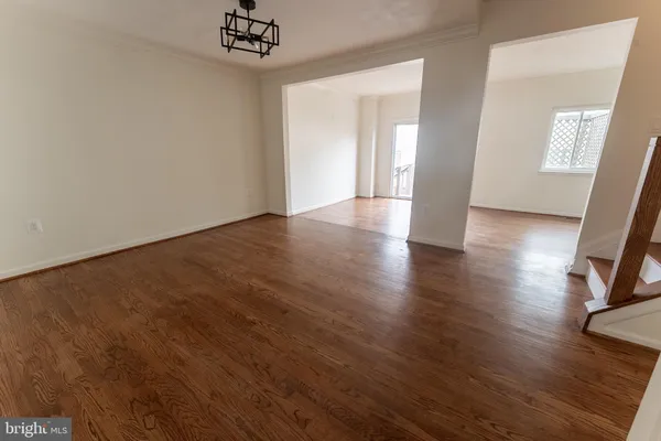 a view of a livingroom with wooden floor and a chandelier