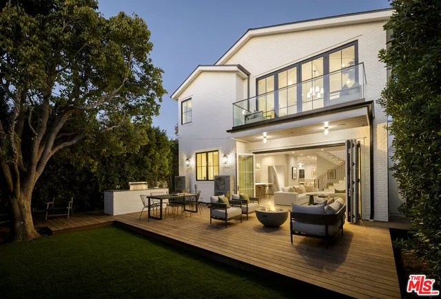 a view of a patio with couches table and chairs and potted plants