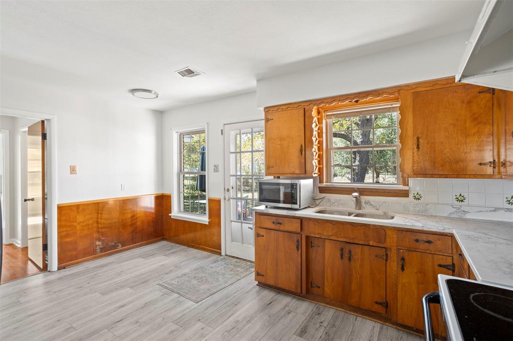 203 Main Street Red Oak, TX 75154 - Photo 11 of 32 a kitchen with a sink and wooden cabinets