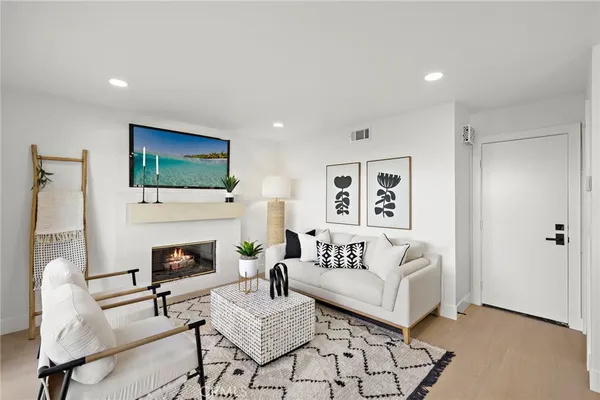 a living room with furniture a flat screen tv and a fireplace