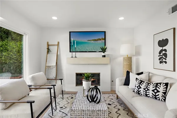 a living room with furniture a fireplace and a flat screen tv