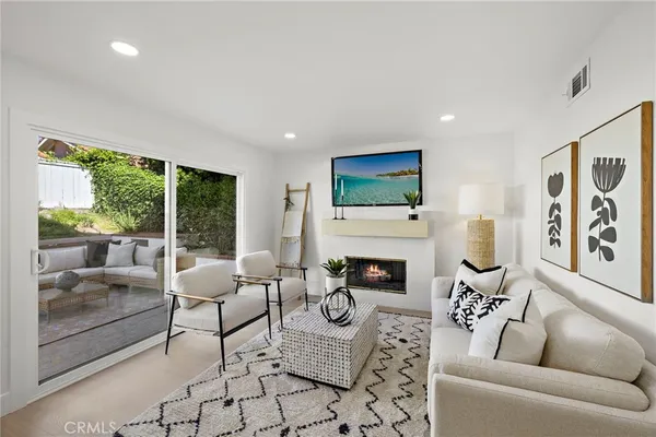 a living room with furniture a flat screen tv and a fireplace