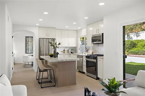 a kitchen with stainless steel appliances kitchen island granite countertop a stove and a refrigerator